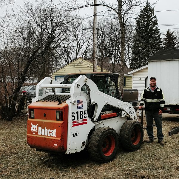 Brett standing with bobcat equipment